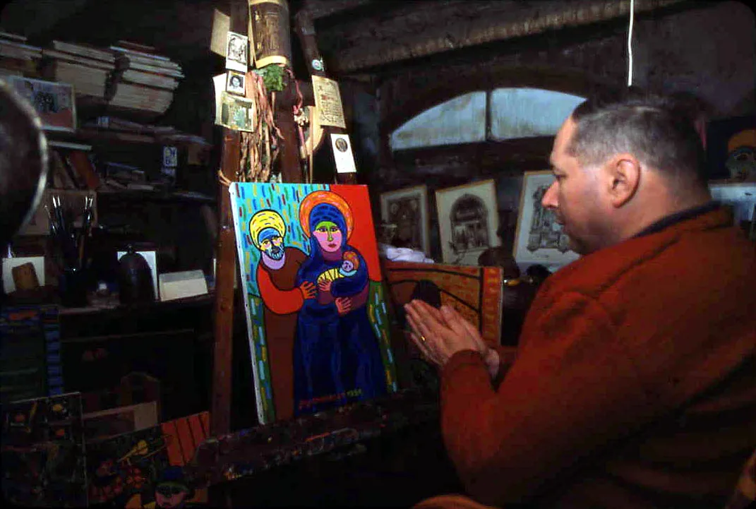 Guy, dans son atelier, face à une toile